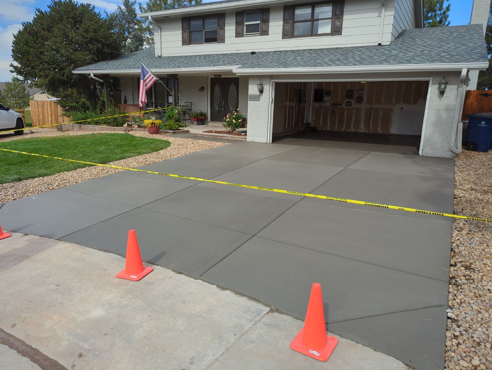 A driveway with orange cones in front of a house