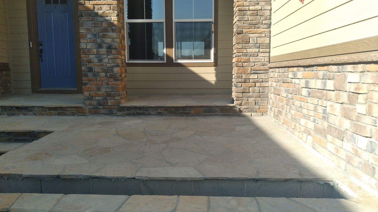 A stone walkway leading to the front door of a house.
