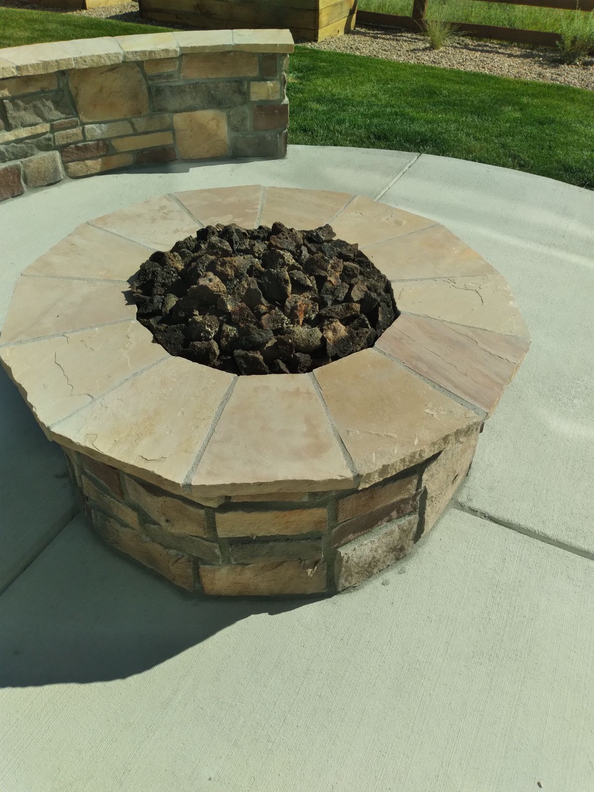 A fire pit made of bricks and rocks on a patio