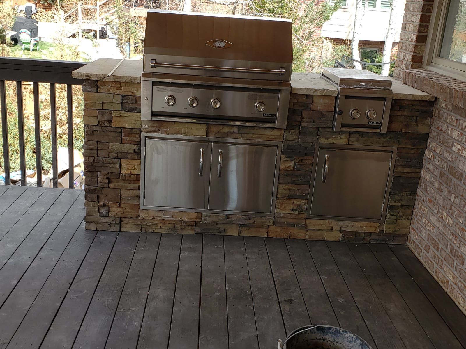 A stainless steel grill is sitting on a wooden deck