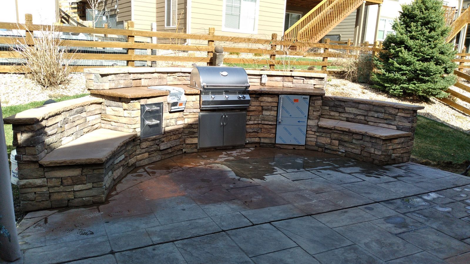 A grill is sitting in the middle of a stone wall.