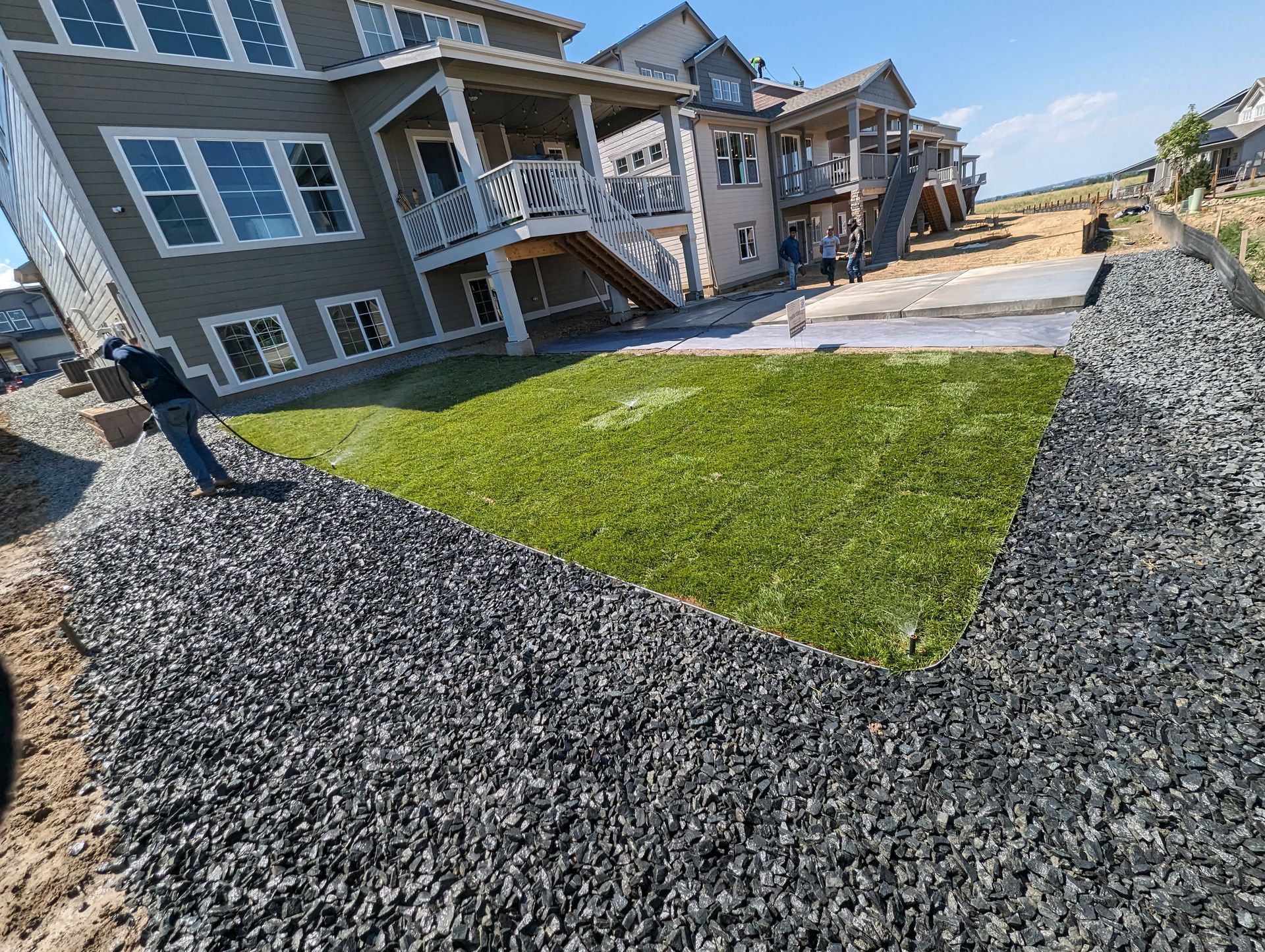 A large house is being built next to a large pile of gravel.