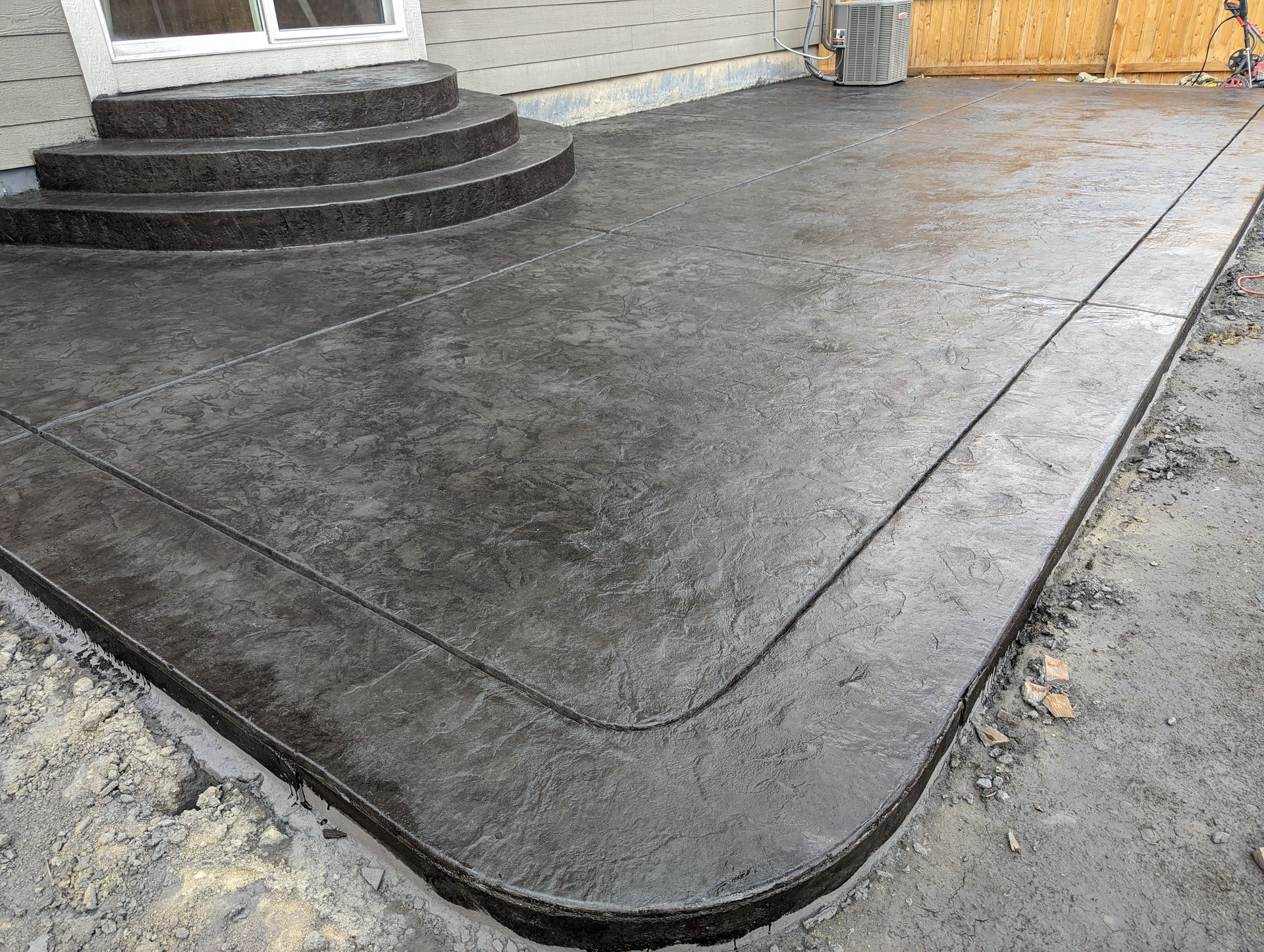 A concrete patio with stairs and steps in front of a house.