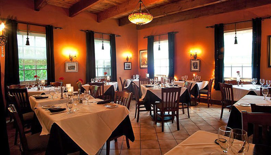 A dining room with tables and chairs and a chandelier