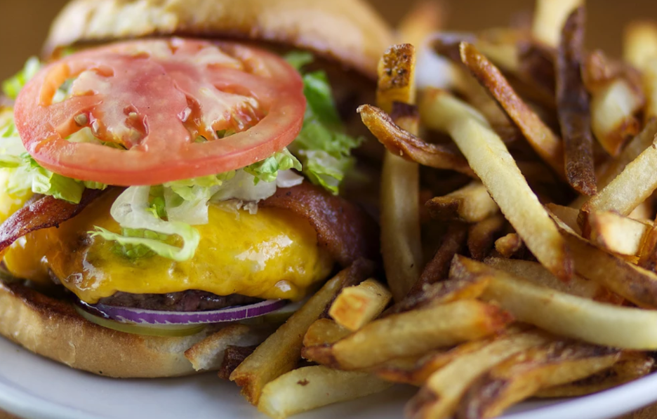 A hamburger and french fries on a white plate.