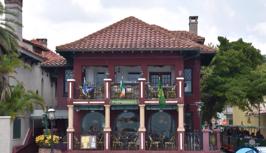 A large red building with a tiled roof and balconies