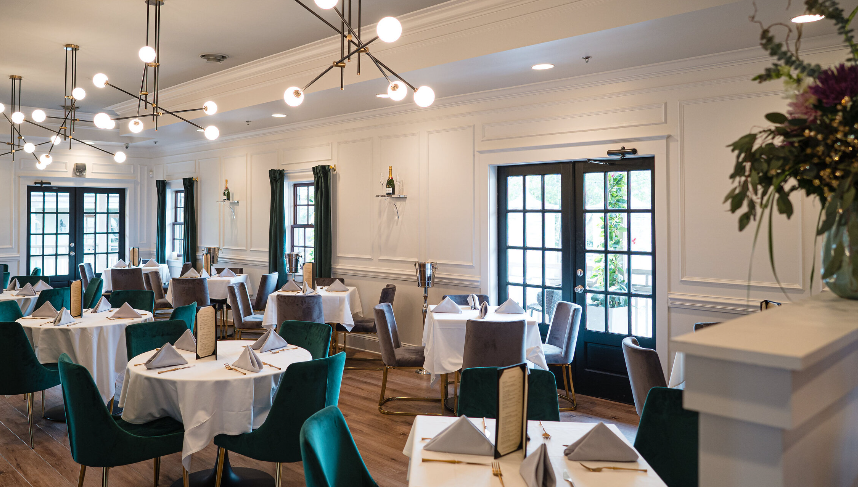 A large dining room filled with tables and chairs and a vase of flowers.