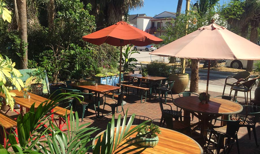 A patio area with tables and chairs and umbrellas