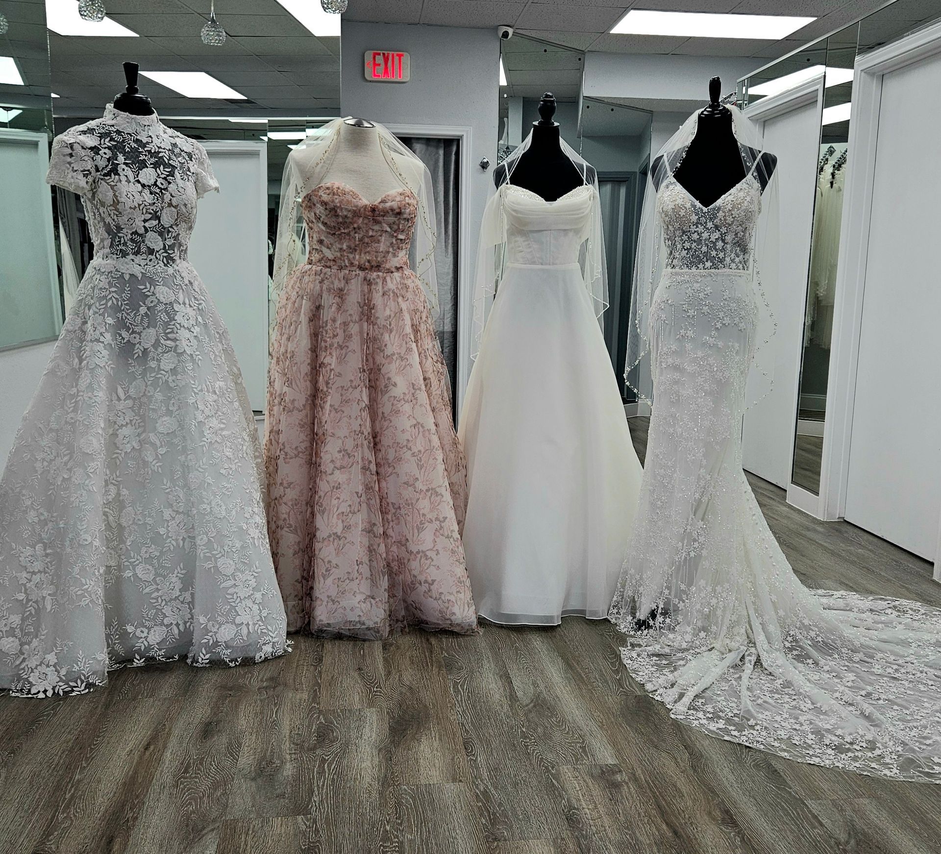 Two wedding dresses are displayed on mannequins in a bridal shop.