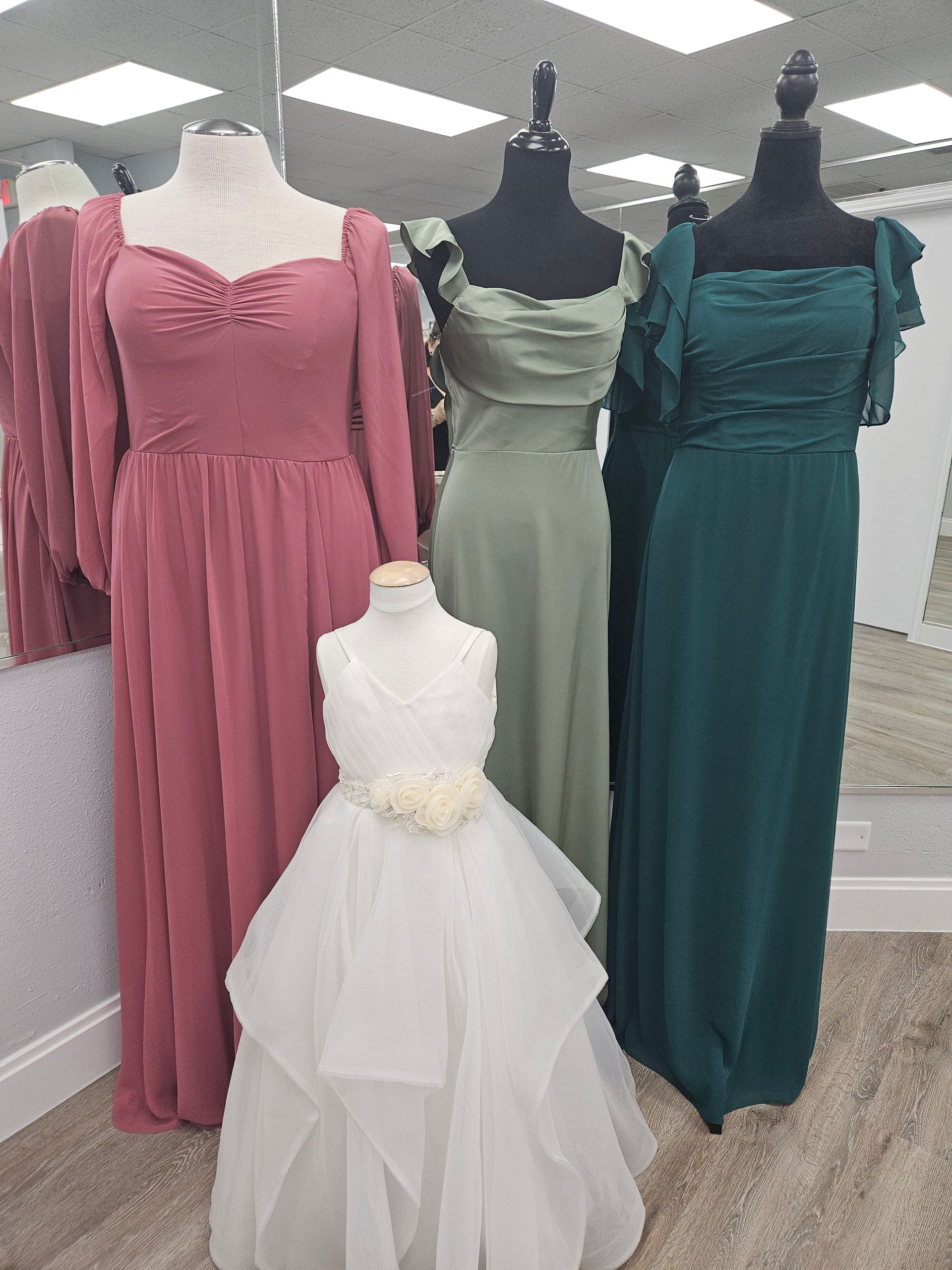 A row of wedding dresses hanging on a rack in a store.