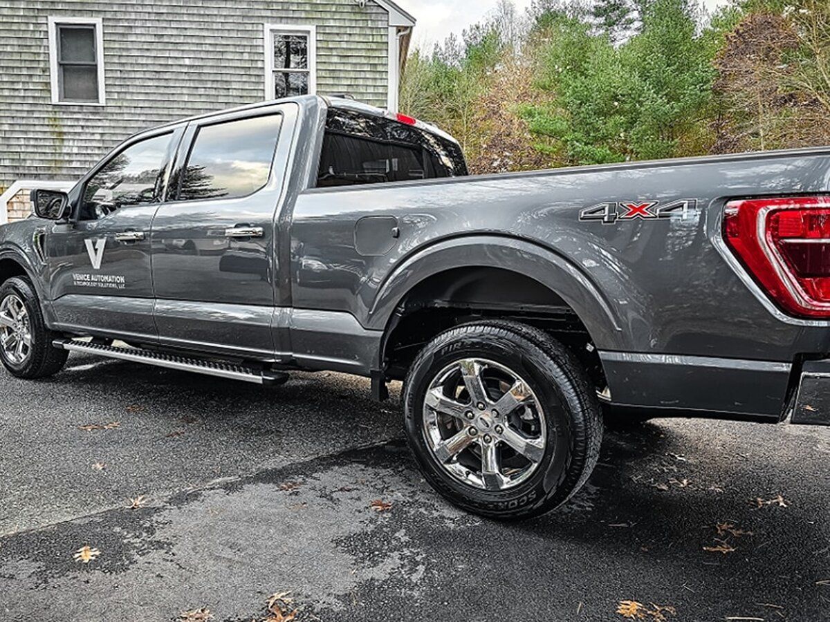 a gray pickup truck is parked in front of a house .