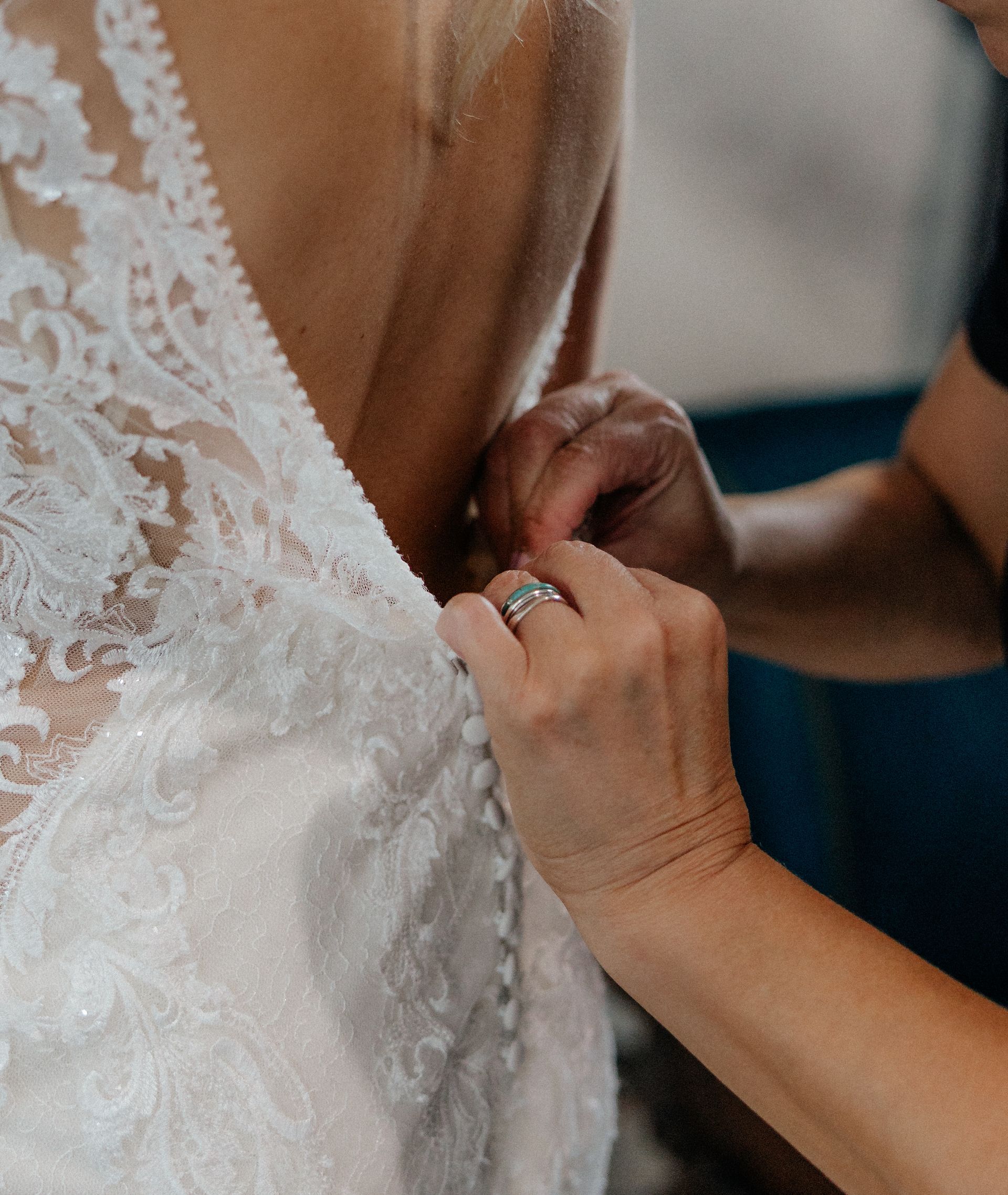Mother of bride buttoning dress