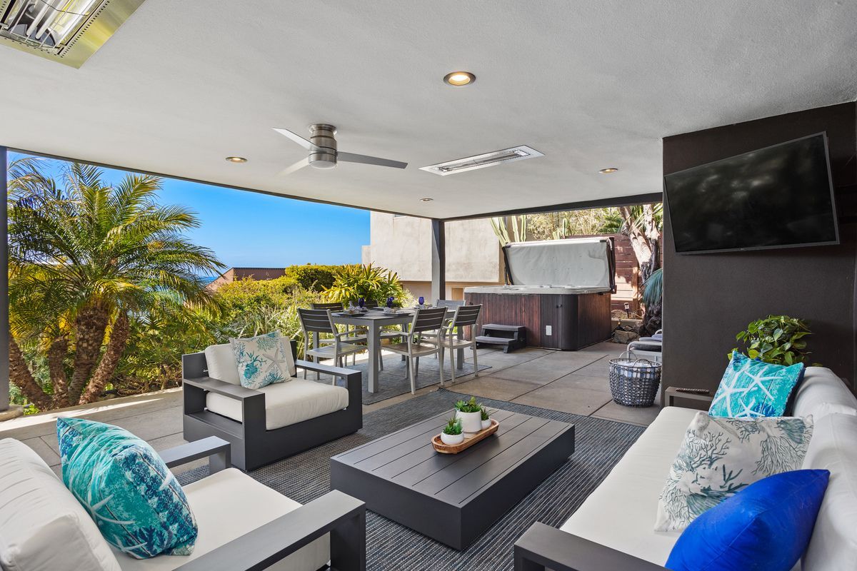A living room with a couch , chairs , table and television.