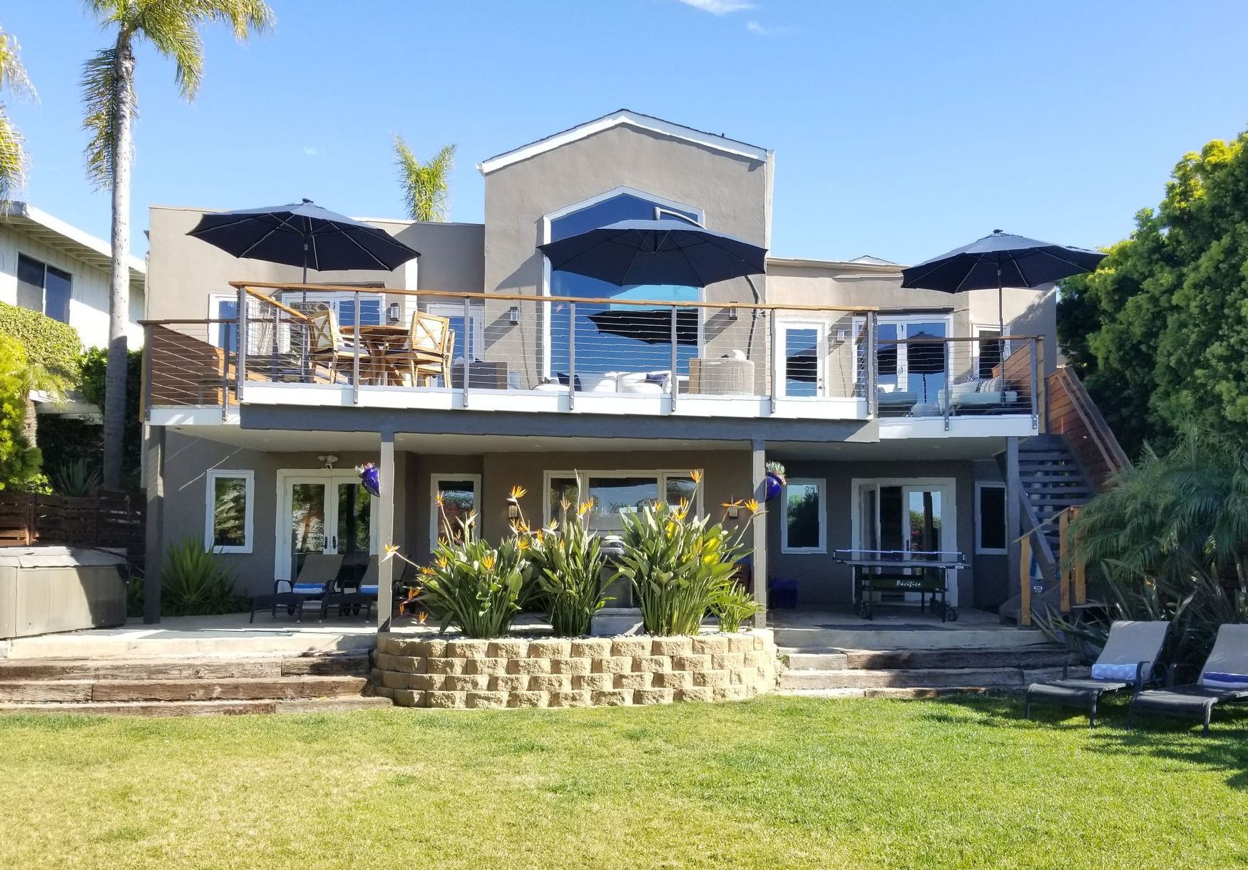 A large house with a lot of windows and umbrellas on the balconies.