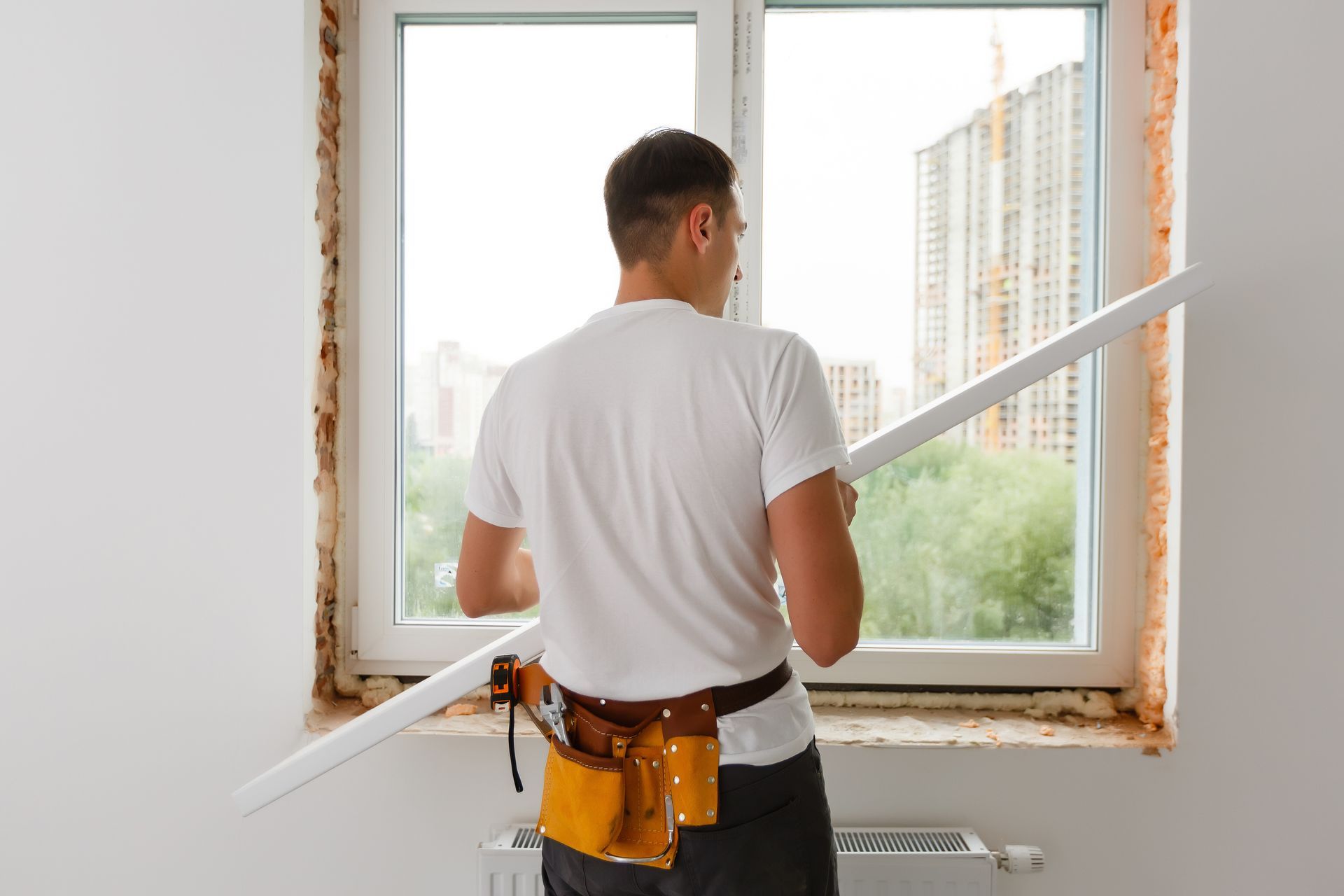 Window Installation — Person installing trim around a window in Cranberry Township, PA