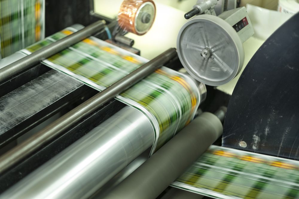 Printing Press With Rolls of Paper Feeding Through, Displaying Green and Yellow Patterned Design — C & D Manufacturing In Caboolture, QLD
