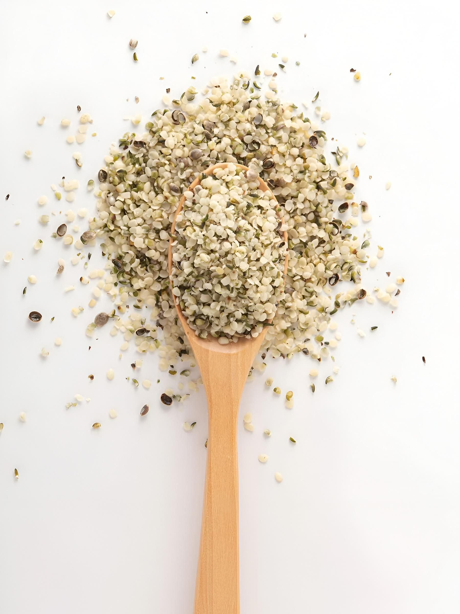 Wooden Spoon Filled With Hemp Seeds on a White Surface; Seeds Are Green and Beige — C & D Manufacturing In Caboolture, QLD