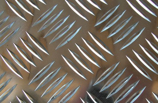 Un primo piano di una superficie metallica con un motivo a scacchi