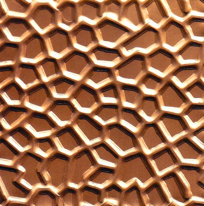 Un primo piano di una lastra di rame con un motivo a nido d'ape