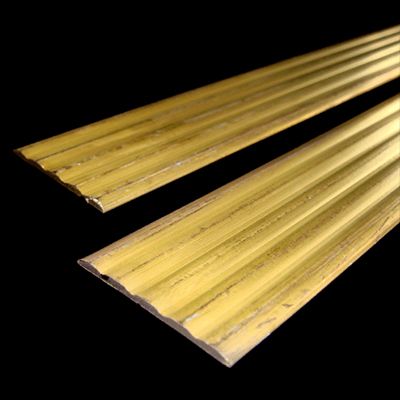 Un paio di profili per scale in ottone su sfondo nero.