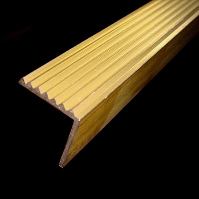 Primo piano di un gradino in ottone su sfondo nero.