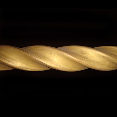 Primo piano di una corda di legno intrecciata su sfondo nero.