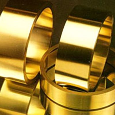 Tre anelli d'oro sono impilati uno sopra l'altro su un tavolo.