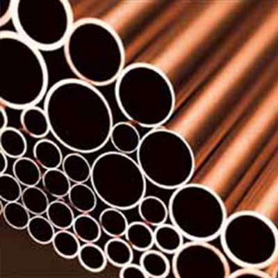 Un mucchio di tubi di rame sono impilati uno sopra l'altro.