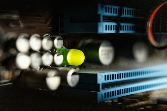 A green and yellow capsule is sitting on top of a computer motherboard.