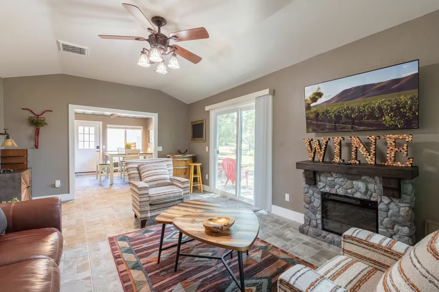 Living room with fireplace, chairs, and sliding door. 