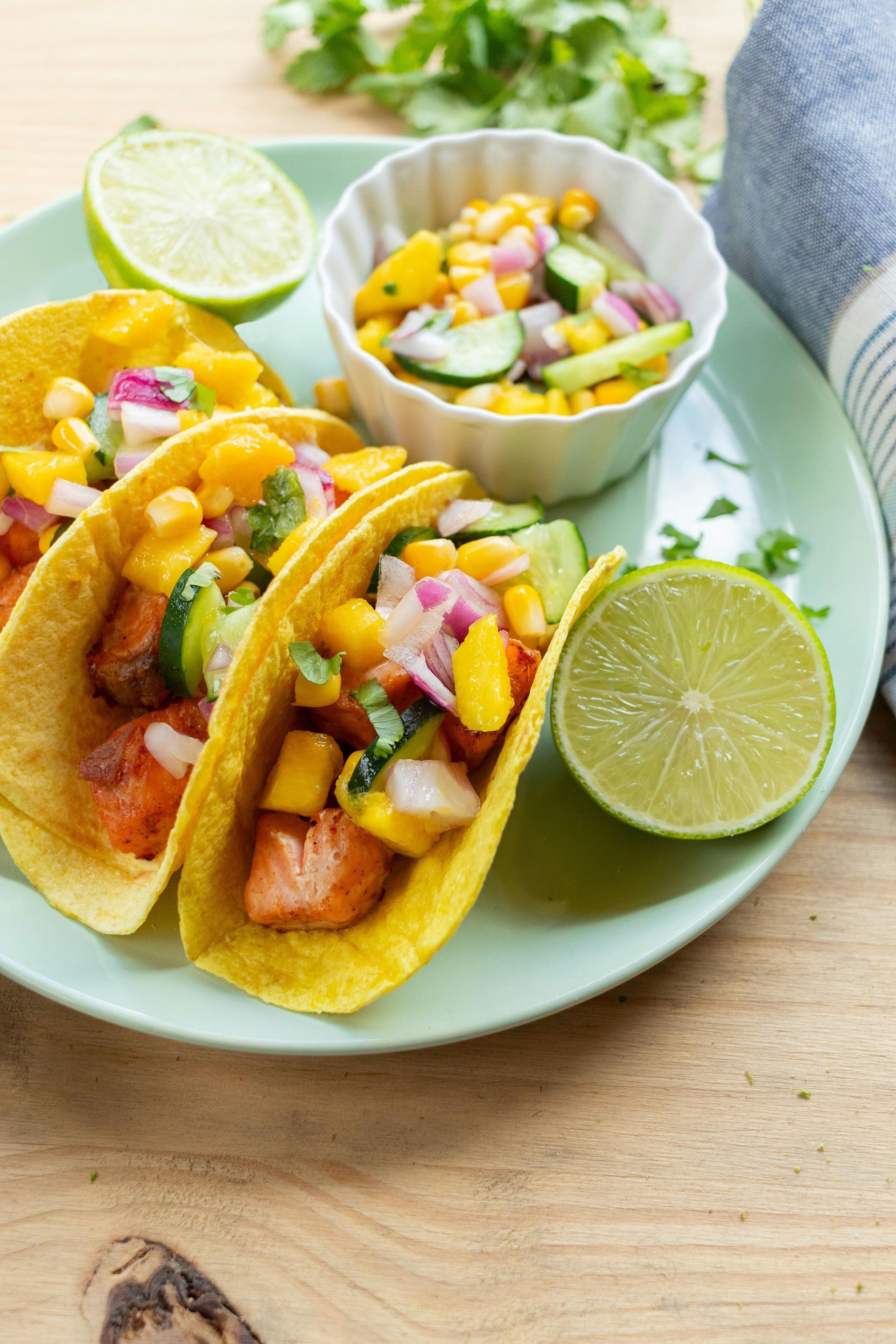 Two seasoned steaks with tomatoes and sauce on a plate.