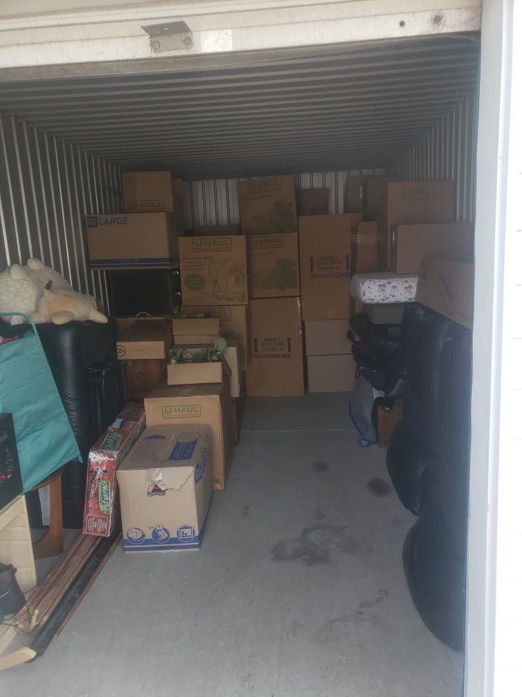 A garage filled with lots of cardboard boxes and tires.