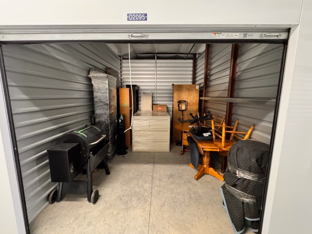 A small storage unit filled with furniture and a grill.