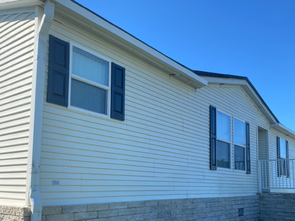 A cleaned white mobile home with black shutters on the windows - Port Charlotte, FL - MD Pressure Cleaning & Soft Wash