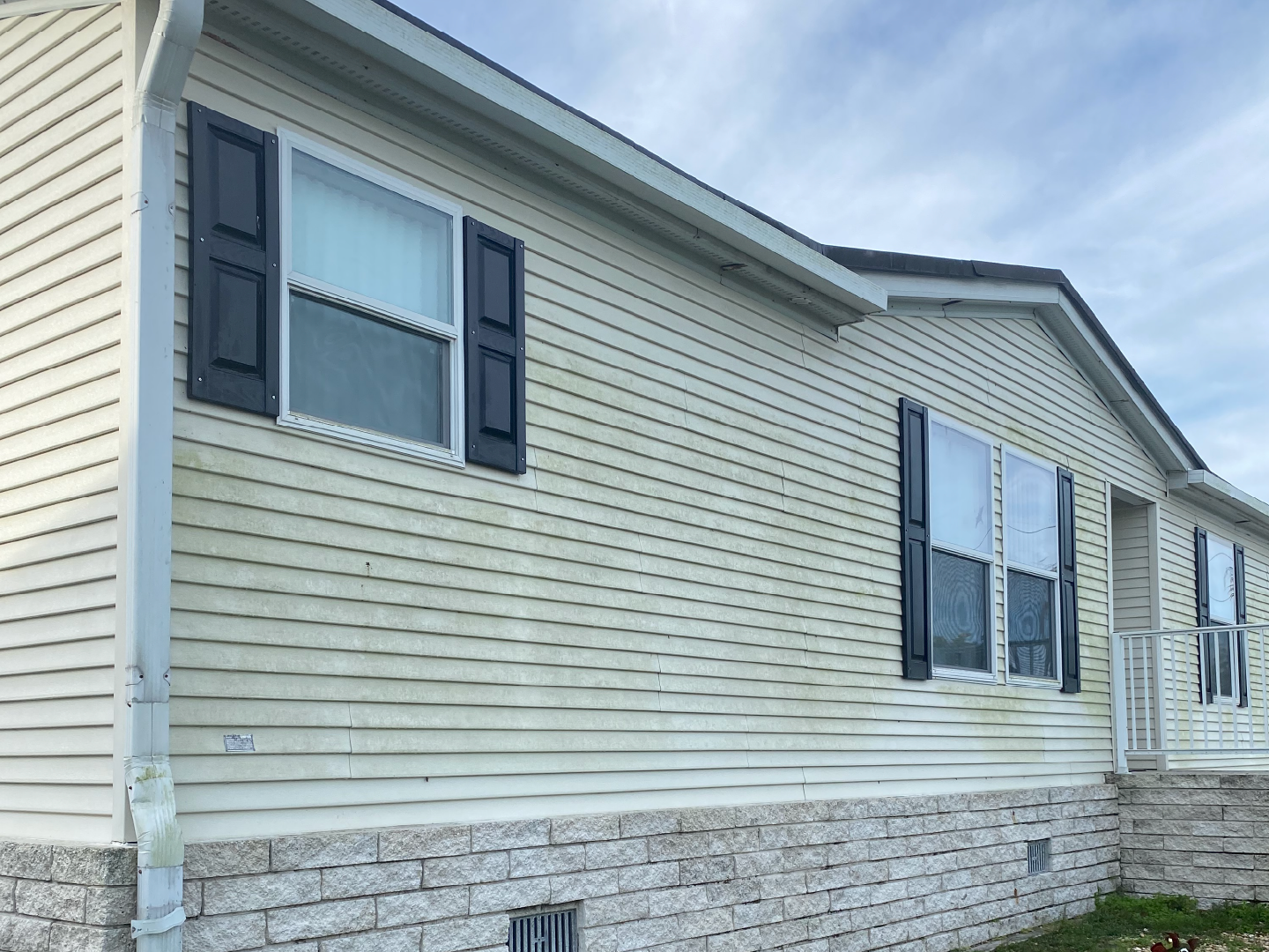 A mobile home with a white siding and black shutters - Port Charlotte, FL - MD Pressure Cleaning & Soft Wash