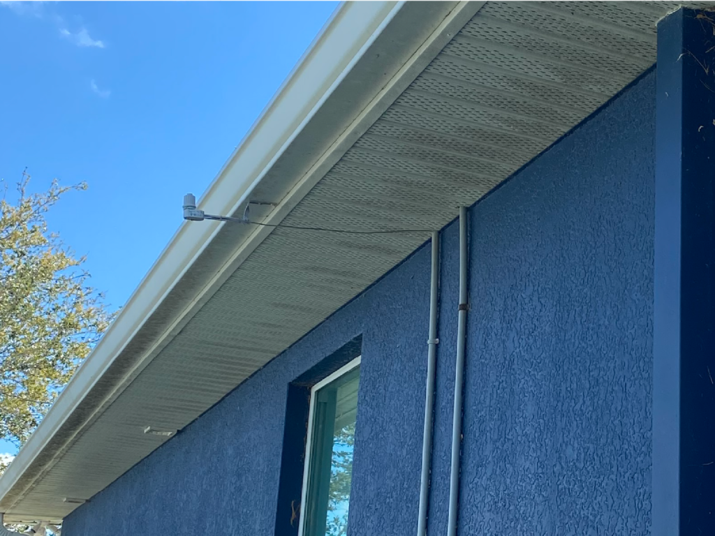 A blue house with a white gutter and a window - Port Charlotte, FL - MD Pressure Cleaning & Soft Wash