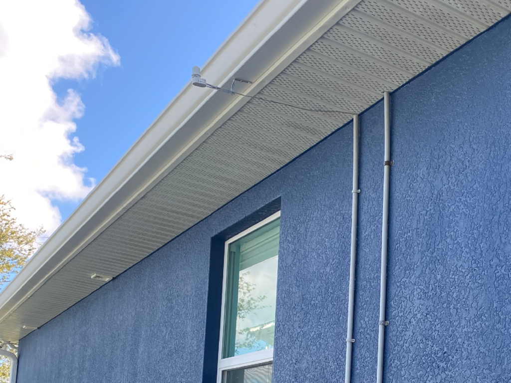 A blue house with a cleaned white gutter and a window - Port Charlotte, FL - MD Pressure Cleaning & Soft Wash