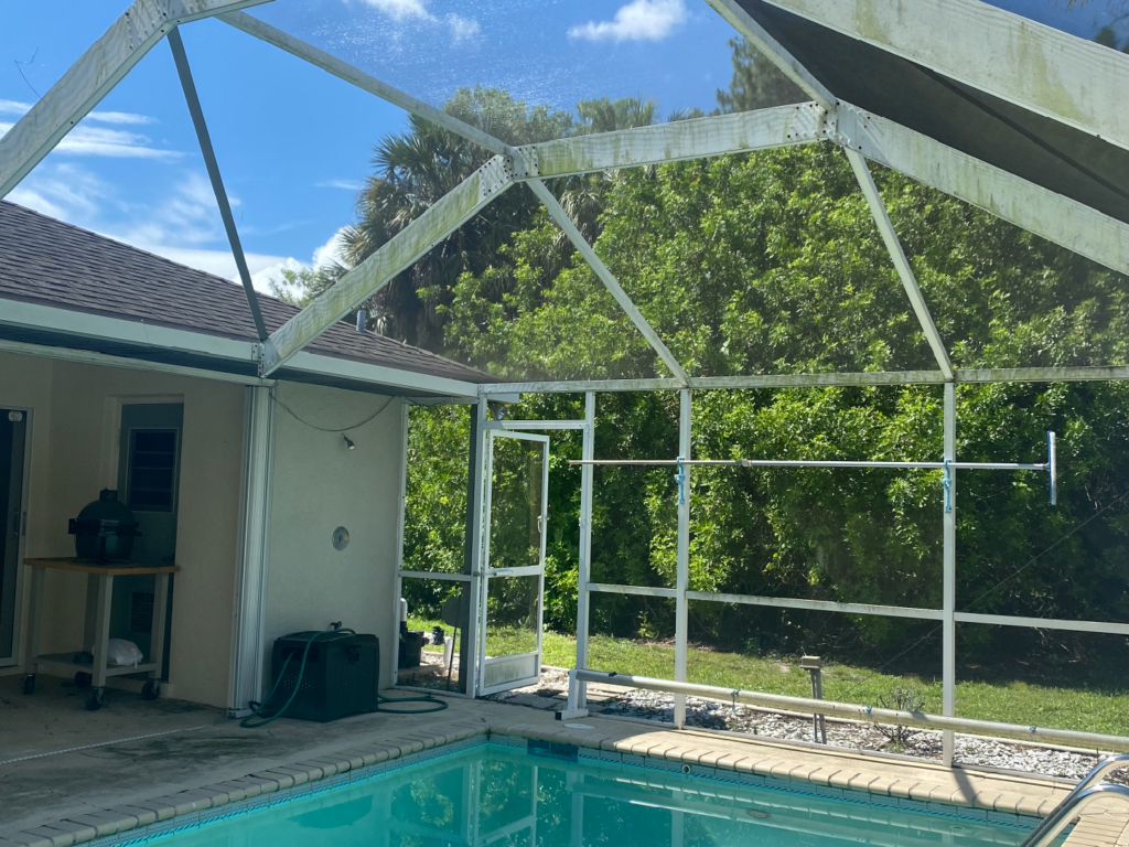 A swimming pool in a screened-in patio in front of a house - Port Charlotte, FL - MD Pressure Cleaning & Soft Wash