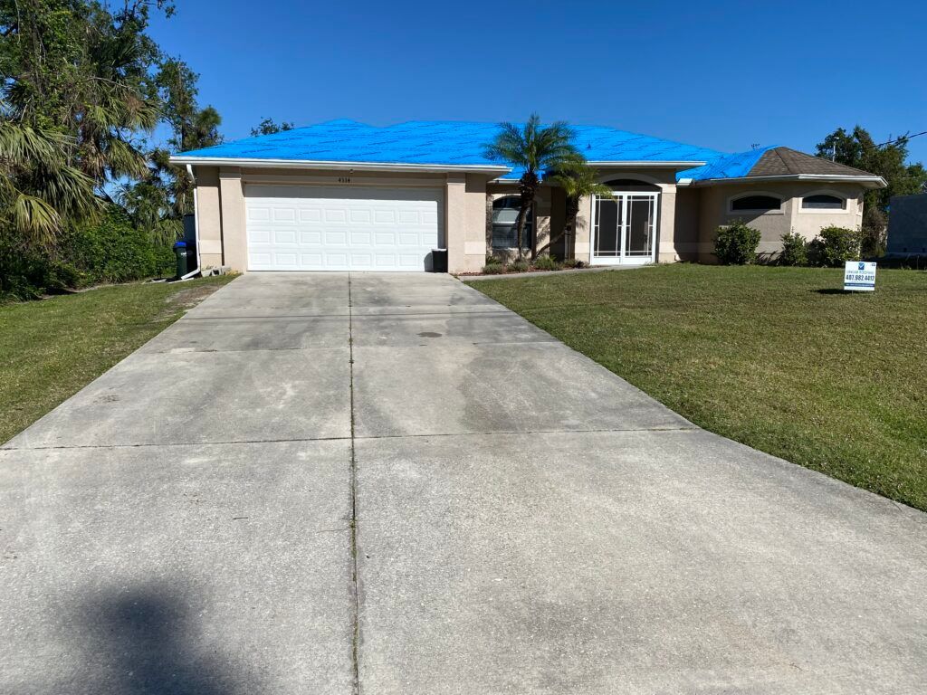 A house with a concrete driveway - Port Charlotte, FL - MD Pressure Cleaning & Soft Wash