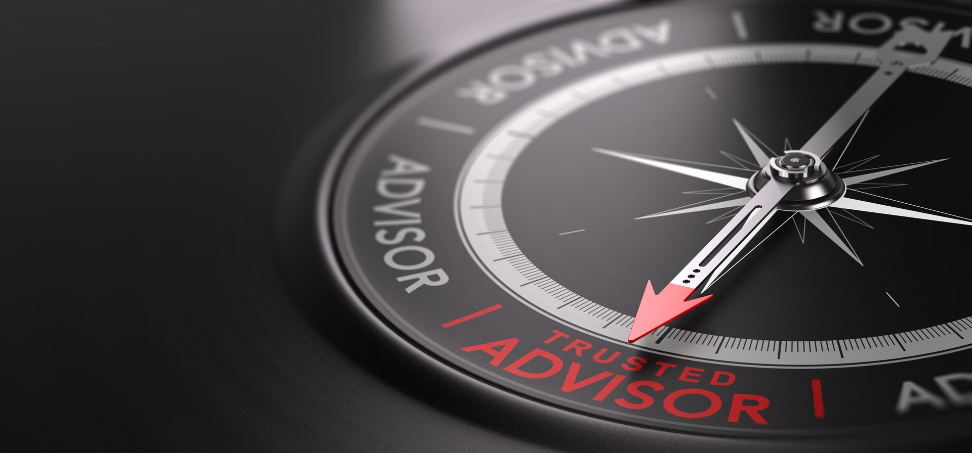 Close-up of a compass on a dark surface, with red “ADVISOR” text on the dial.