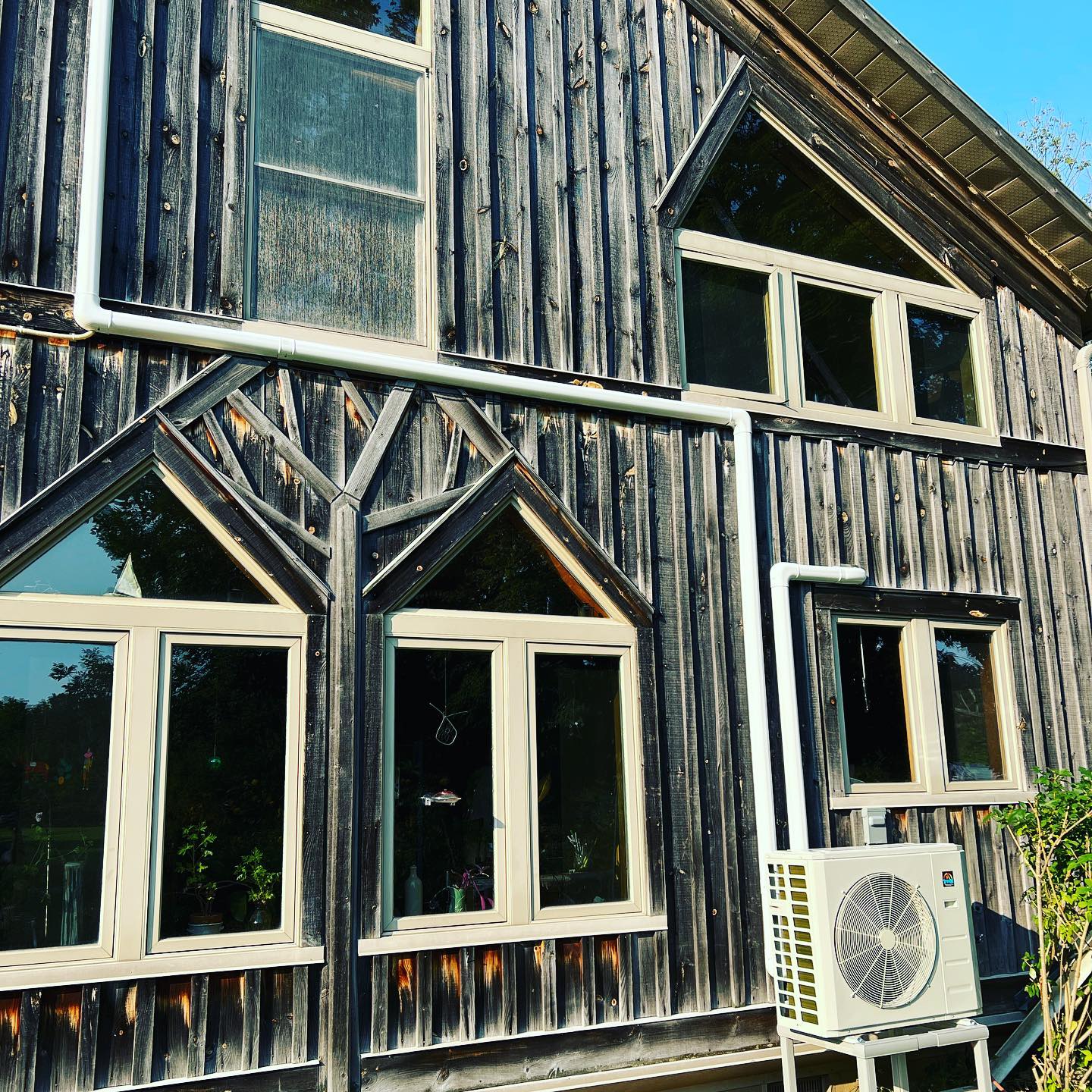 A house with a lot of windows and a fan on the side