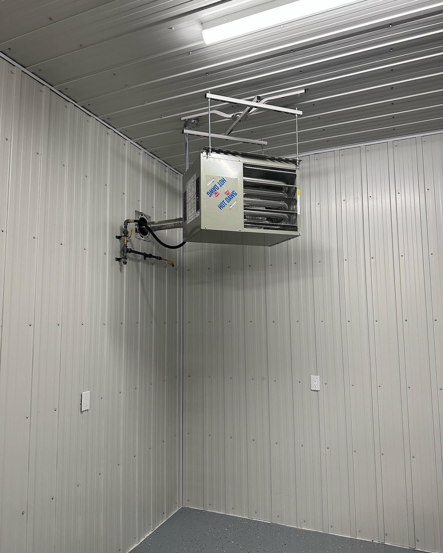 A room with a heater hanging from the ceiling.