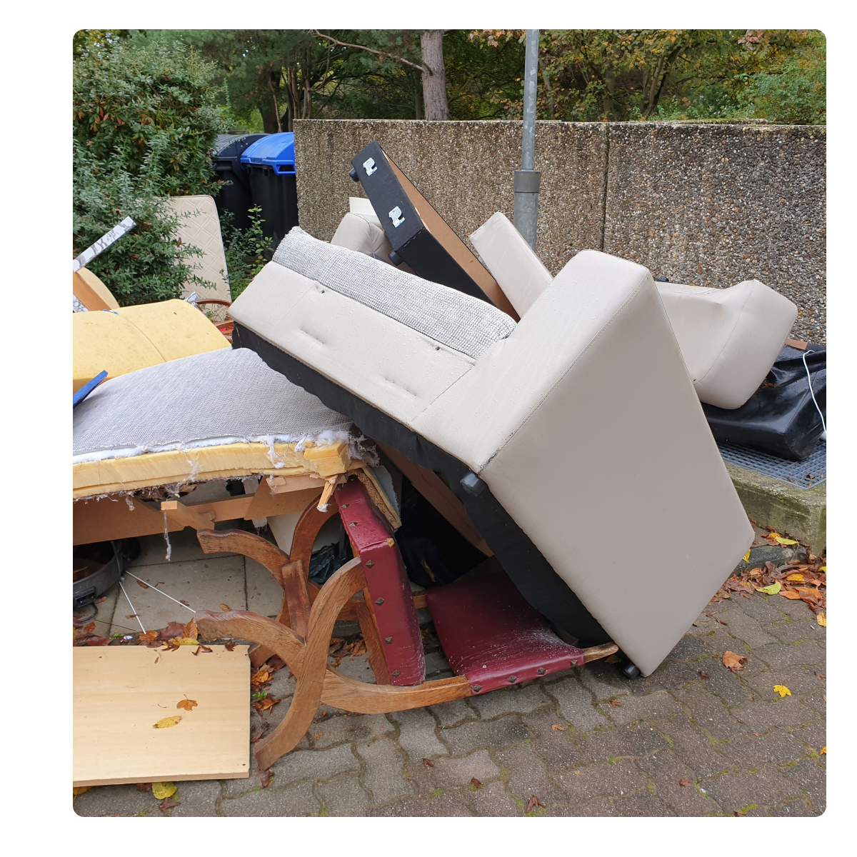 A pile of broken furniture is sitting on the sidewalk.