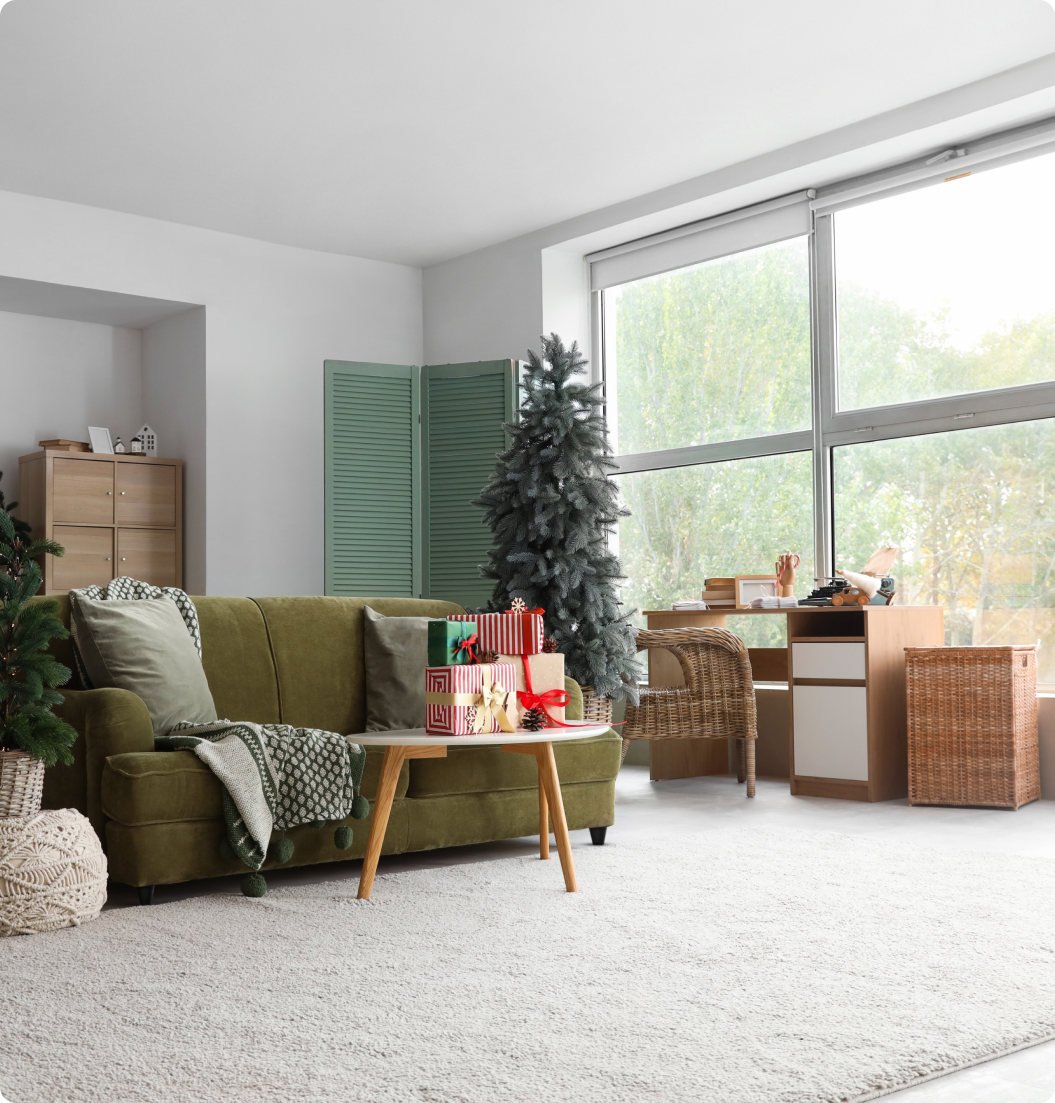 A living room with a green couch and a christmas tree.