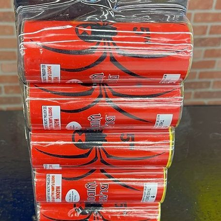 A bunch of red cans with a spider on them are stacked on top of each other on a table.