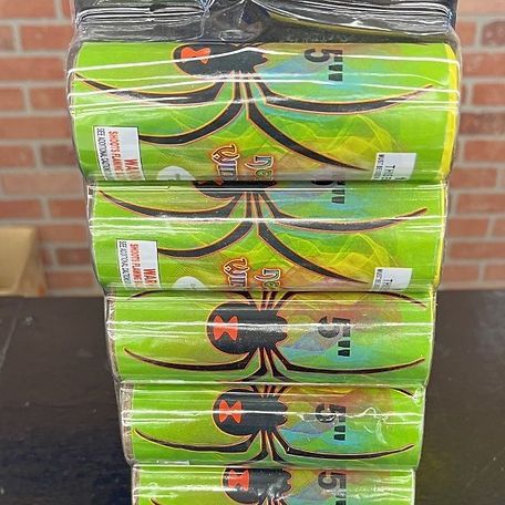 A stack of green cans with spiders on them are sitting on a table.