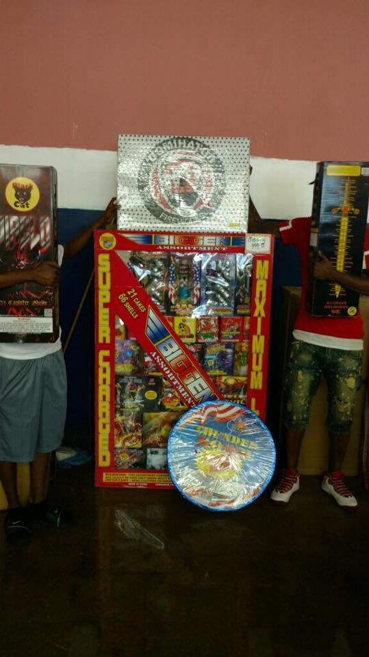 A group of people are standing in front of a display of fireworks.