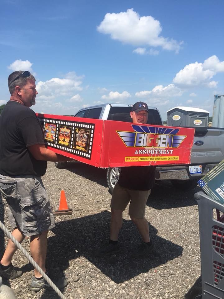 Two men are carrying a large red box that says big jim