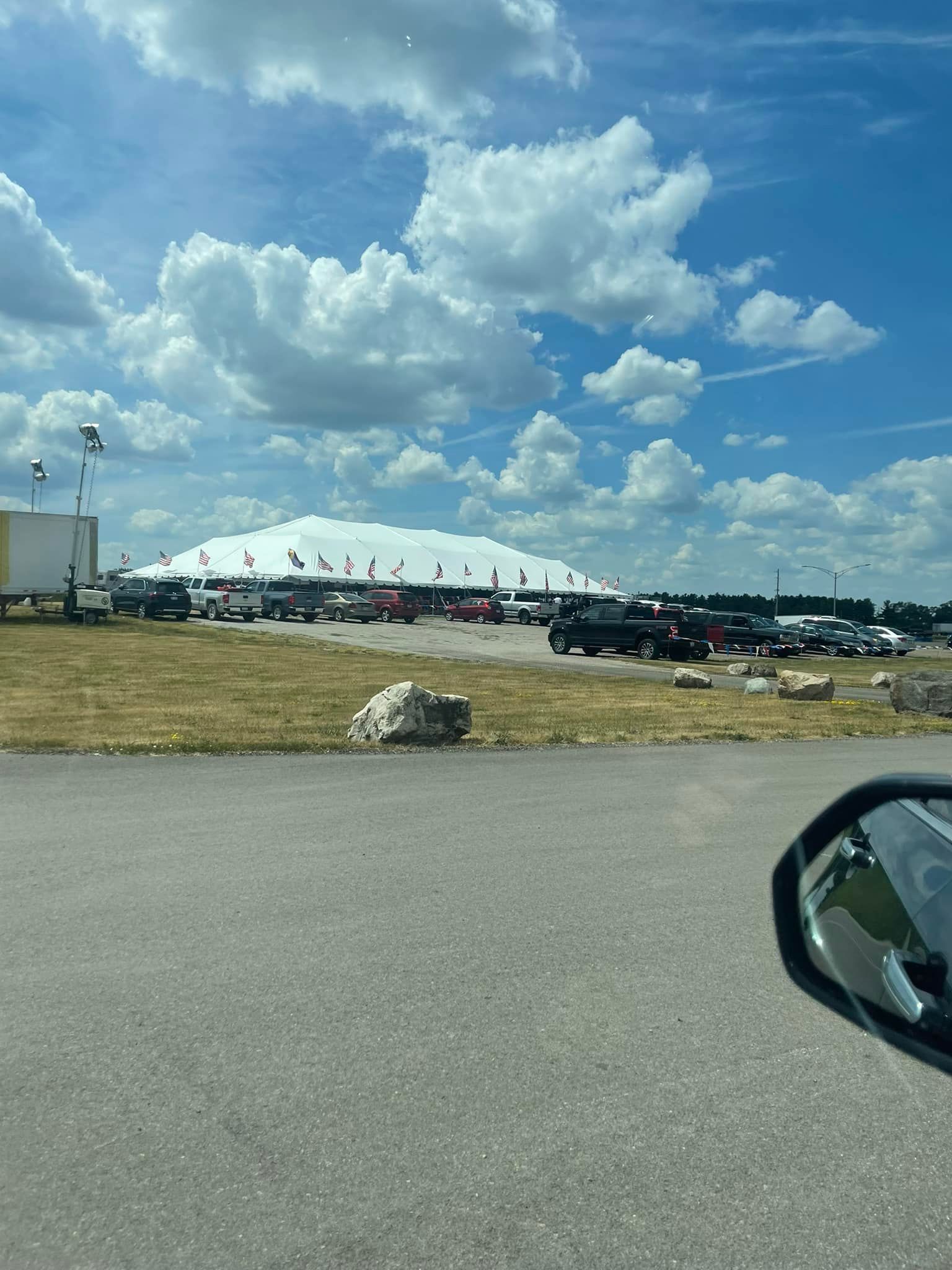 A large white tent is sitting in the middle of a parking lot.