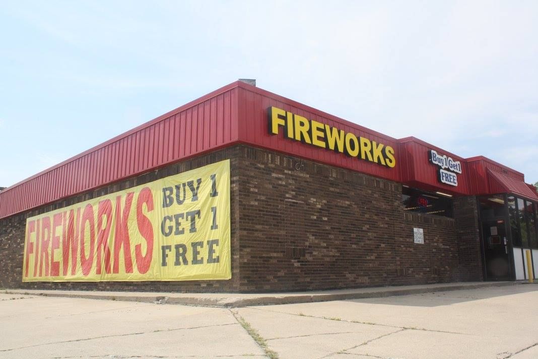 A fireworks store with a sign on the side that says `` buy 1 get 1 free ''.